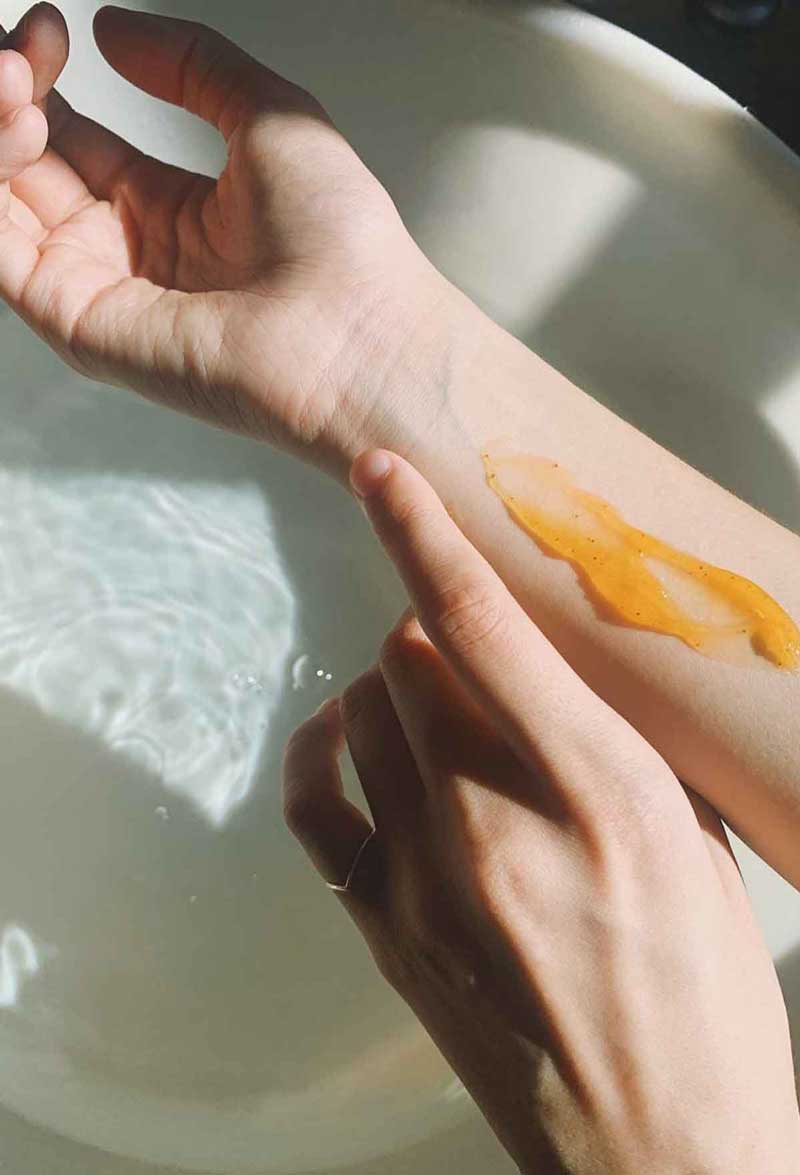 picture of a woman applying too much skincare product which can be an acne trigger