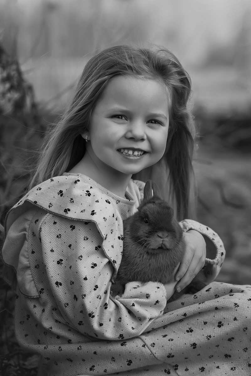 picture of a little girl holding a rabbit in her hands in black and white