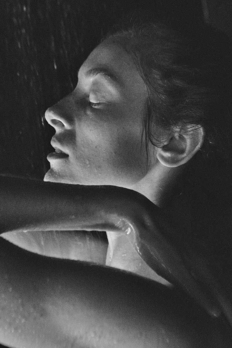 woman with dry skin concerns taking a shower, black and white picture