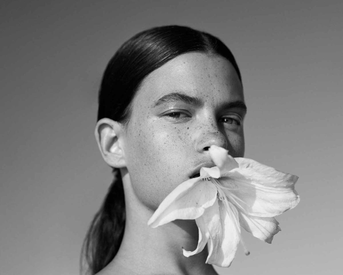 image of a beautiful woman in black and white holding a flower in her mouth