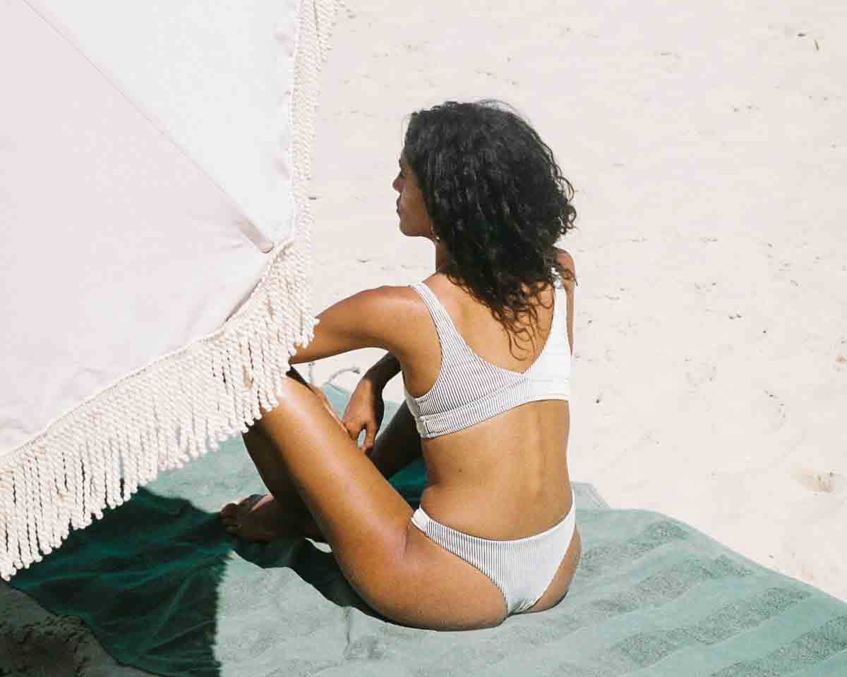 Cover image of the article The natural Skin Care Routine for Melasma and Chloasma showing a woman sunbathing