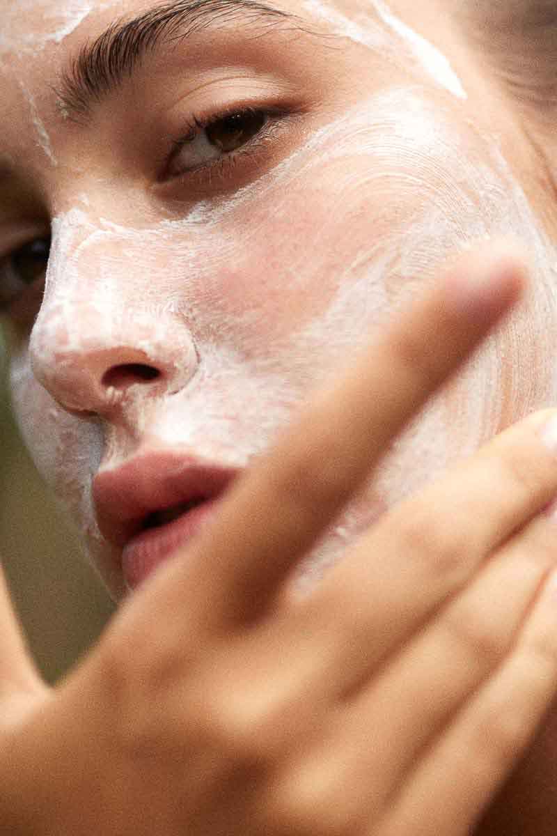 image of a woman applying a fields of yarrow face mask