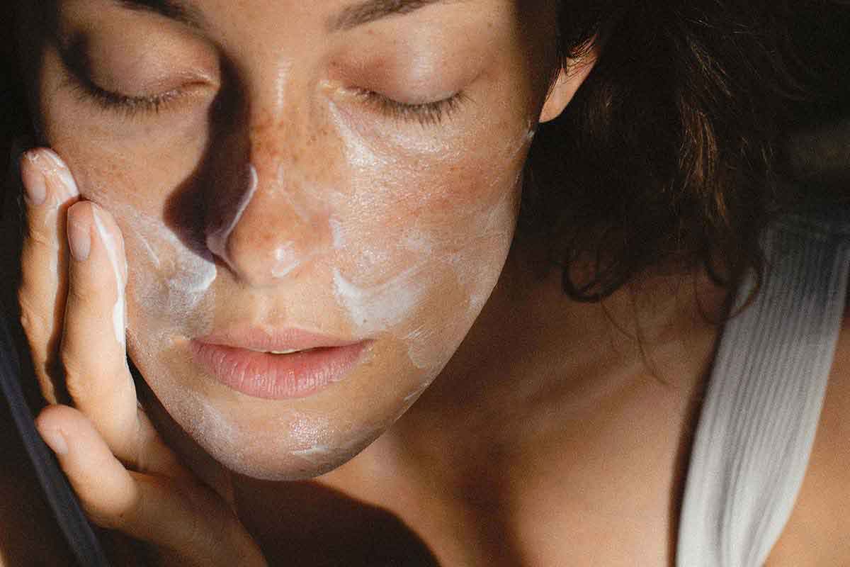 picture of a young woman using products for fine lines on her face