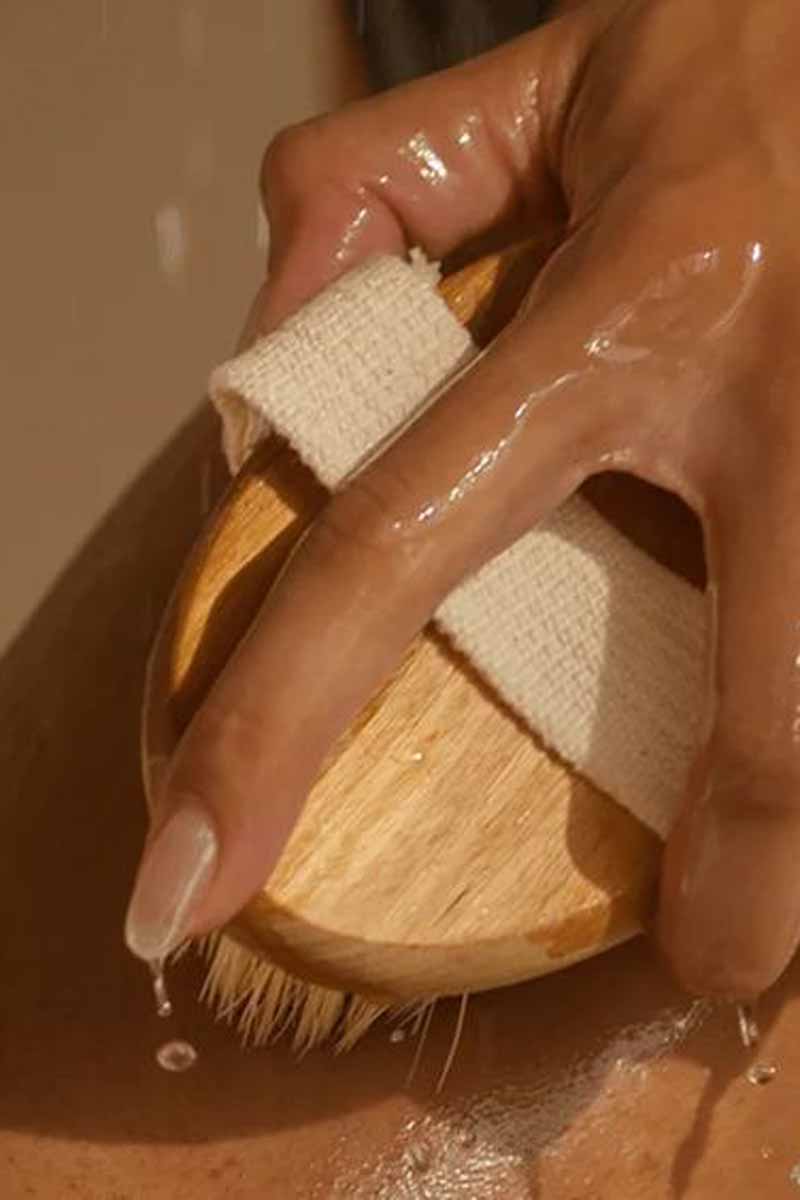 closeup image of a woman clensing their skin with a weekly skincare routine under the shower<br />
