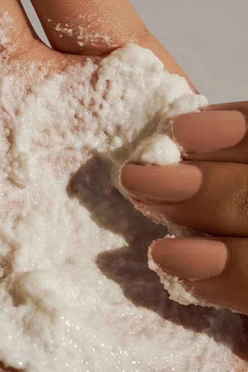 close up of a woman's fingers mixing ingredients for her weekly skin care routine