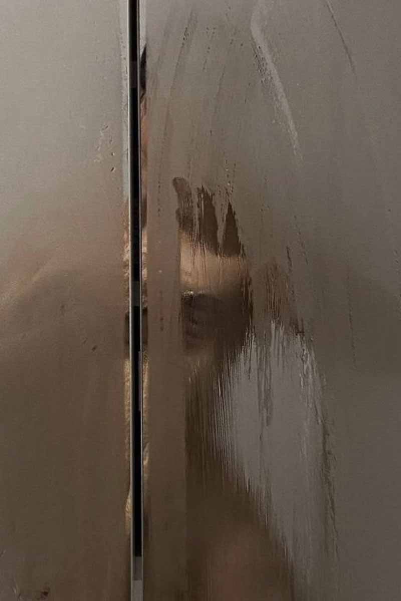 image of a young woman taking a shower, covered by the steam, during her weekly skincare routine<br />
