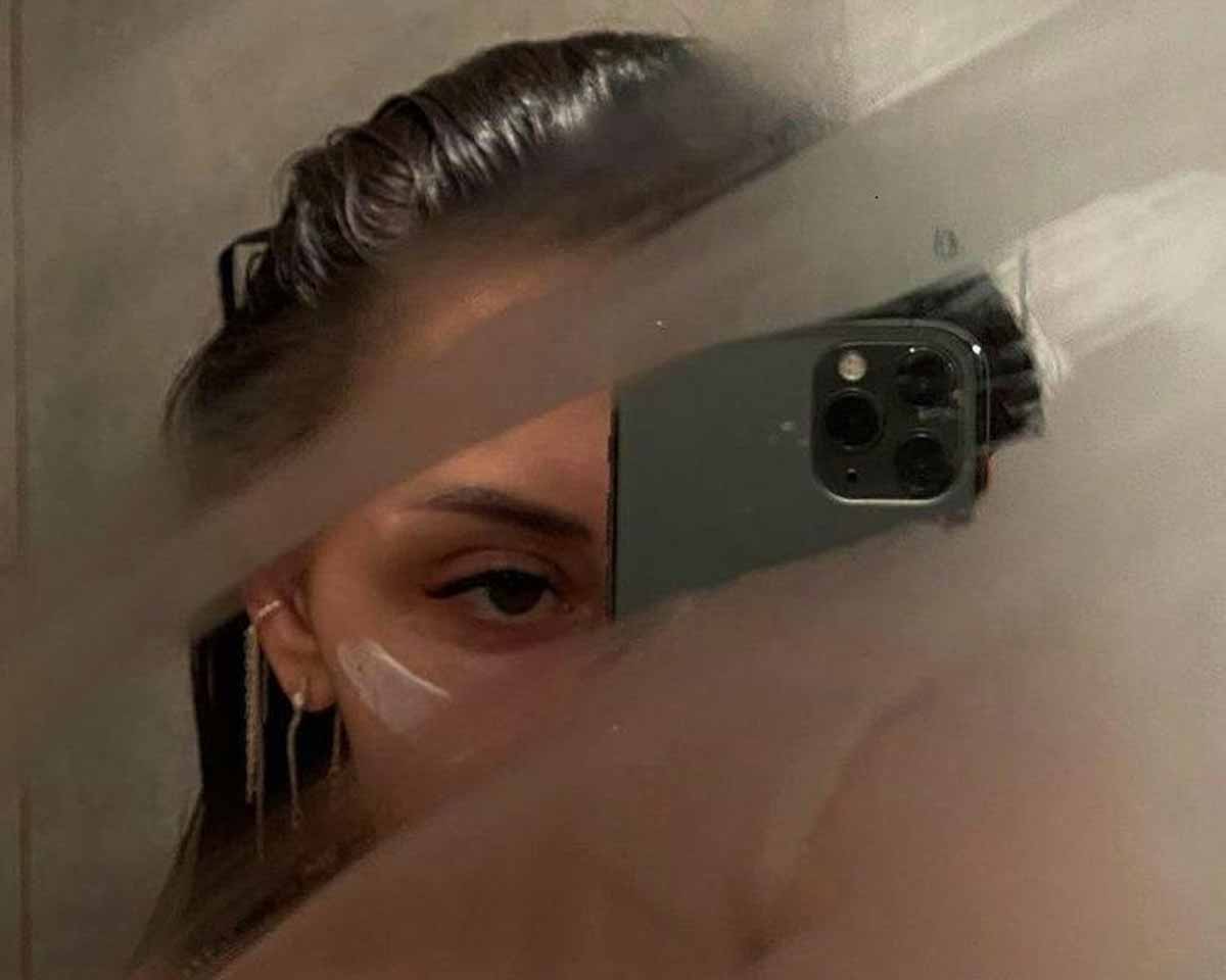 Cover image for the article How to Achieve a Glowing Complexion with a Weekly Skin care Routine showing a girl taking a selfie at the mirror
