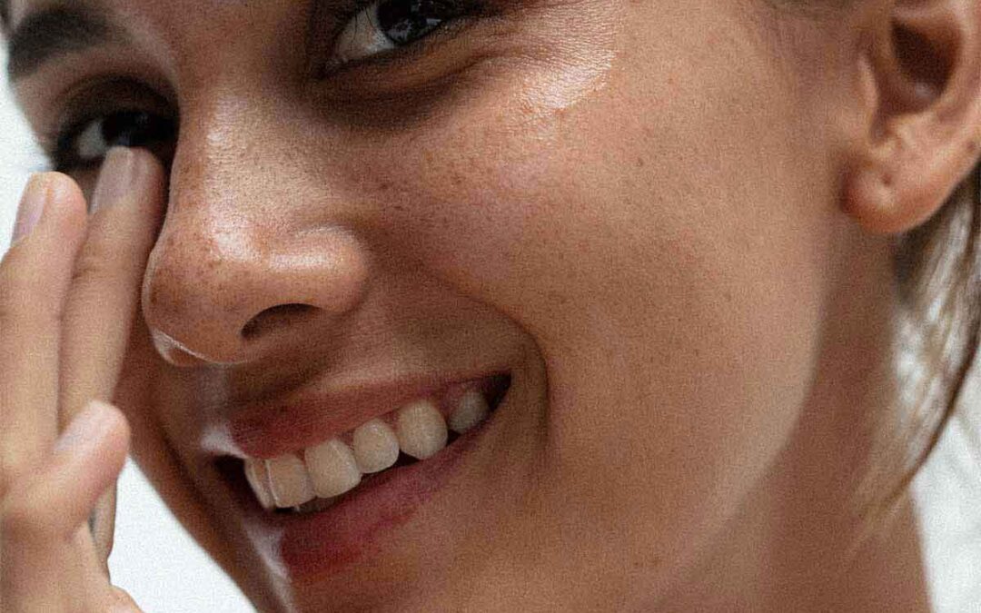 cover image for the article on superfoods for dry skin showing a woman satisfied with her skin