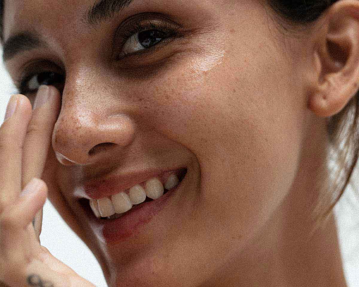 cover image for the article on superfoods for dry skin showing a woman satisfied with her skin