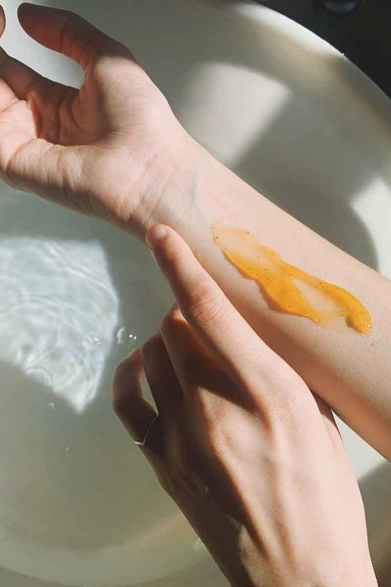 image of a woman patch testing her skin care product on her arm skin