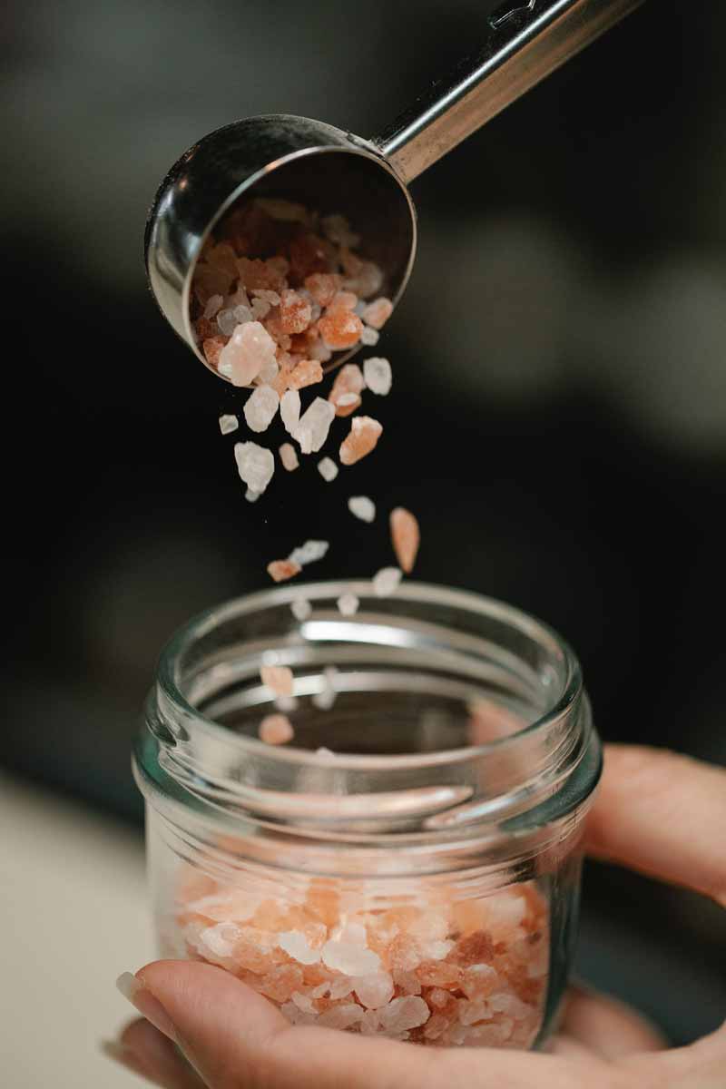 picture showing minerals being poured in a jar with a spoon