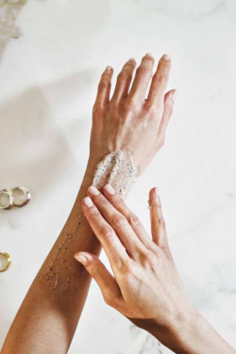 picture of a woman putting moringa based skincare products on her arms